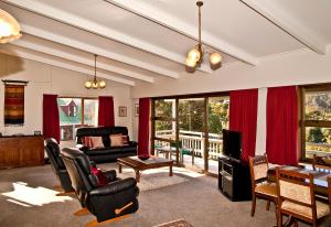 a living room with a couch and a table and chairs at High Tides in Ngunguru