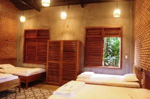 a room with three beds and a window at Paksong Farmstay Gia Lai - Venuestay in Pleiku