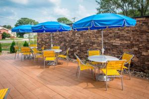 eine Terrasse mit Tischen, Stühlen und blauen Sonnenschirmen in der Unterkunft Fairfield Inn & Suites by Marriott Waterloo Cedar Falls in Waterloo