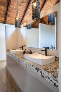 twee wastafels op een stenen aanrecht in een badkamer bij Xoot ka Ana luxury, Villa las Flores in Bacalar