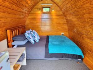 a bedroom with a bed in a wooden cabin at Flat Hills Tourist Park in Ruahine