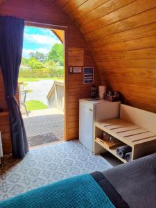 Habitación con puerta que da a una cocina con nevera. en Flat Hills Tourist Park en Ruahine