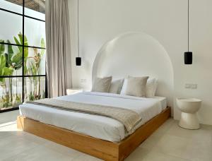 Un dormitorio blanco con una cama con una ventana grande. en Two- bedroom Luxury Villas, en Uluwatu