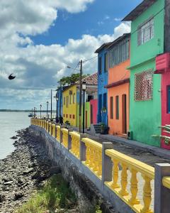 a row of colorful houses next to the water at Caravelas casa de Abrolhos in Caravellas