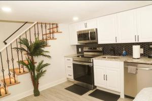 cocina con armarios blancos y estufa negra en 1 Bed 1 Bath Suite, en Washington