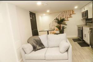 a living room with a white couch and a staircase at 1 Bed 1 Bath Suite in Washington