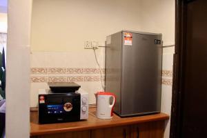 eine Küche mit einer Mikrowelle und einem Kühlschrank auf der Theke in der Unterkunft D'Melor Penthouse Glory Beach Resort in Port Dickson