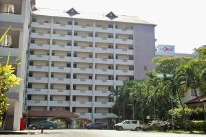 un gran edificio con coches estacionados frente a él en D'Melor Penthouse Glory Beach Resort, en Port Dickson