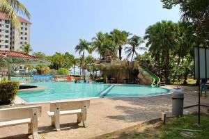 una piscina con un tobogán en un complejo en D'Melor Penthouse Glory Beach Resort en Port Dickson