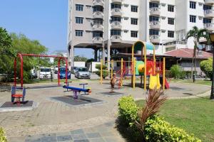 un parque infantil en un parque frente a un edificio en D'Melor Penthouse Glory Beach Resort, en Port Dickson
