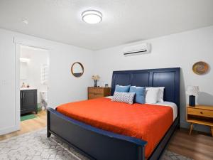 ein Schlafzimmer mit einem großen Bett mit einer orangefarbenen Decke in der Unterkunft Grace's View, full kitchen, close to skiing in Sandy