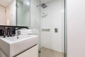 a white bathroom with a sink and a shower at Effortless Local Living on Greville Street in Melbourne