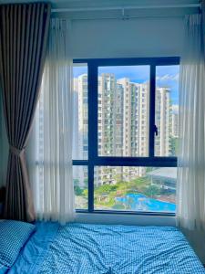 a bedroom with a window with a view of a city at Căn hộ 2pn2wc Celadon City Aeon Mall Tân Phú in Ho Chi Minh City