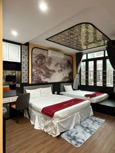 a bedroom with two beds and a desk and windows at OYO 1219 Thien Han Phat Hotel in Da Nang