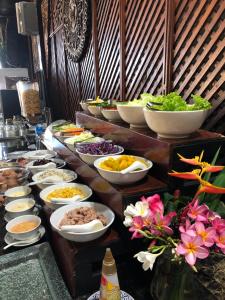 ein Buffet mit Schalen und Teller mit Speisen in der Unterkunft Anda Lipe Resort in Ko Lipe