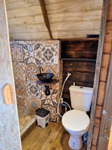 een badkamer met toilet in een houten huis bij Aldeia Ananda Imbituba in Imbituba +14 foto's