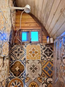 een kamer met mozaïeken op de vloer van een kamer bij Aldeia Ananda Imbituba in Imbituba