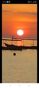 ein Boot im Wasser mit Sonnenuntergang in der Unterkunft Pondok Shindu Guest House in Pemuteran