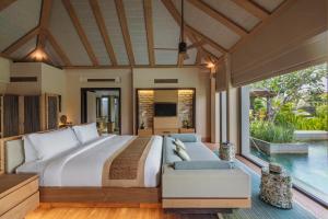 a bedroom with a large bed and a pool at The Ritz-Carlton Bali in Nusa Dua