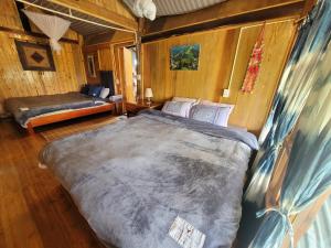 ein Schlafzimmer mit einem großen Bett in einer Hütte in der Unterkunft Sapa's Soul in Sa Pa
