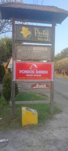 un panneau pour une boutique de donuts sur le côté d'une route dans l'établissement Pondok Shindu Guest House, à Pemuteran