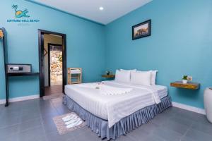 a bedroom with a large bed with a blue wall at Koh Rong Hill Beach Resort in Koh Rong Island