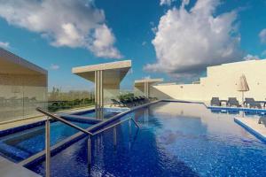 a swimming pool with blue water in a building at Habitación Privada Riviera Maya, Playa del Carmen! in Playa del Carmen