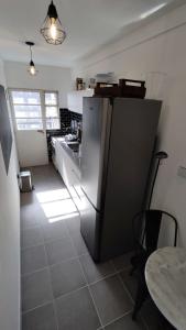 una cucina con frigorifero in acciaio inossidabile e tavolo di Cozy apartment in Palermo - La Rural a Buenos Aires