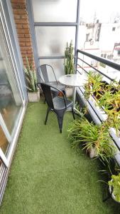 um pátio com uma mesa e uma cadeira na varanda em Cozy apartment in Palermo - La Rural em Buenos Aires