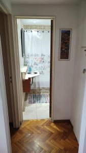 uma casa de banho com um chuveiro, um lavatório e um espelho. em Cozy apartment in Palermo - La Rural em Buenos Aires