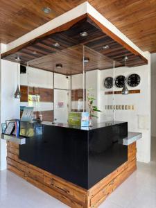 uma cozinha com um balcão preto e tectos em madeira em North Stellar Hotel and Events-Place em Batac