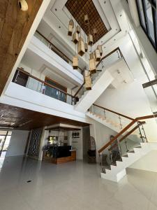 uma sala de estar aberta com uma escada e um lustre em North Stellar Hotel and Events-Place em Batac