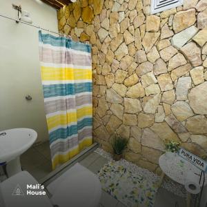 a bathroom with a shower with a stone wall at Mali's House in Fortuna