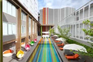 un edificio con un colorido pasillo con sillas y sombrillas en Tinidee Trendy Bangkok Khaosan, en Bangkok