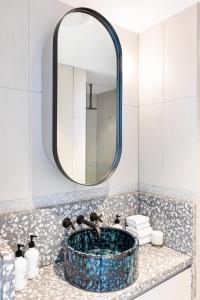 W łazience znajduje się umywalka z lustrem. w obiekcie The 249 Apartments by Urban Rest w mieście Sydney