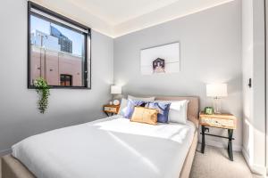 una camera con un letto bianco e una finestra di The 249 Apartments by Urban Rest a Sydney