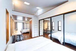1 Schlafzimmer mit 2 Betten und einem Schreibtisch in der Unterkunft サテライトホテル六本木/Satellite Hotel Roppongi in Tokio
