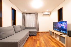 サテライトホテル六本木/Satellite Hotel Roppongi في طوكيو: غرفة معيشة مع أريكة وتلفزيون بشاشة مسطحة