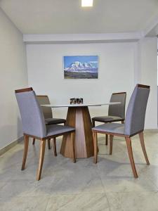 een vergaderzaal met een tafel en vier stoelen bij New Dawn Rio in Riobamba