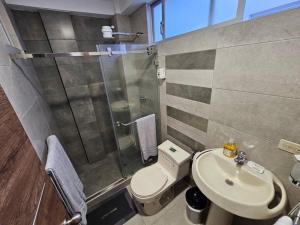 een badkamer met een douche, een toilet en een wastafel bij New Dawn Rio in Riobamba