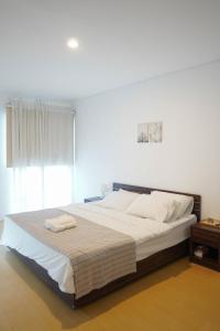 1 dormitorio con 1 cama grande y 2 toallas. en No303, en Bandung