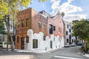 ceglany budynek z białą fasadą na ulicy w obiekcie The 249 Apartments by Urban Rest w mieście Sydney