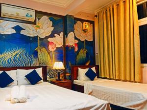 a hotel room with two beds and a mural at Hue Pink Lotus Hotel in Hue