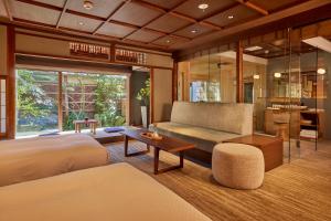 a bedroom with a bed and a couch and a table at HOTEL VMG RESORT KYOTO in Gionmachi