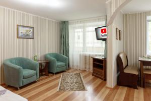 Habitación de hotel con 2 sillas y TV en Кейптаун, en Petropavlovsk