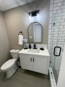 a bathroom with a toilet and a sink and a mirror at Apt 5 - High Plains Lodge at Nomad Landing in Clayton