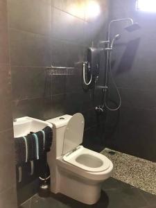 La salle de bains est pourvue de toilettes, d'une douche et de serviettes. dans l'établissement Casa tiga homestay besut, à Kampung Kuala Besut