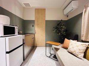 a living room with a couch and a microwave at HOTEL KANMA UENO in Tokyo