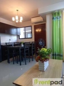 cocina y comedor con mesa y cortina verde en Fully Furnished 3 Bedroom House + Public Pool + Wi-Fi + Air conditioning en Mandaue City