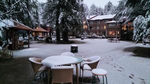 帕哈尔加姆Welcomhotel by ITC Hotels, Pine N Peak, Pahalgam的院子里雪覆盖的桌子和椅子